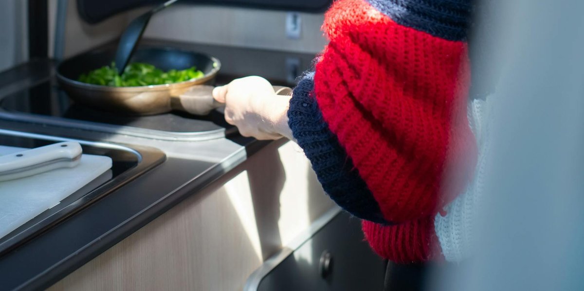 Woman cooking inside an RV kitchen