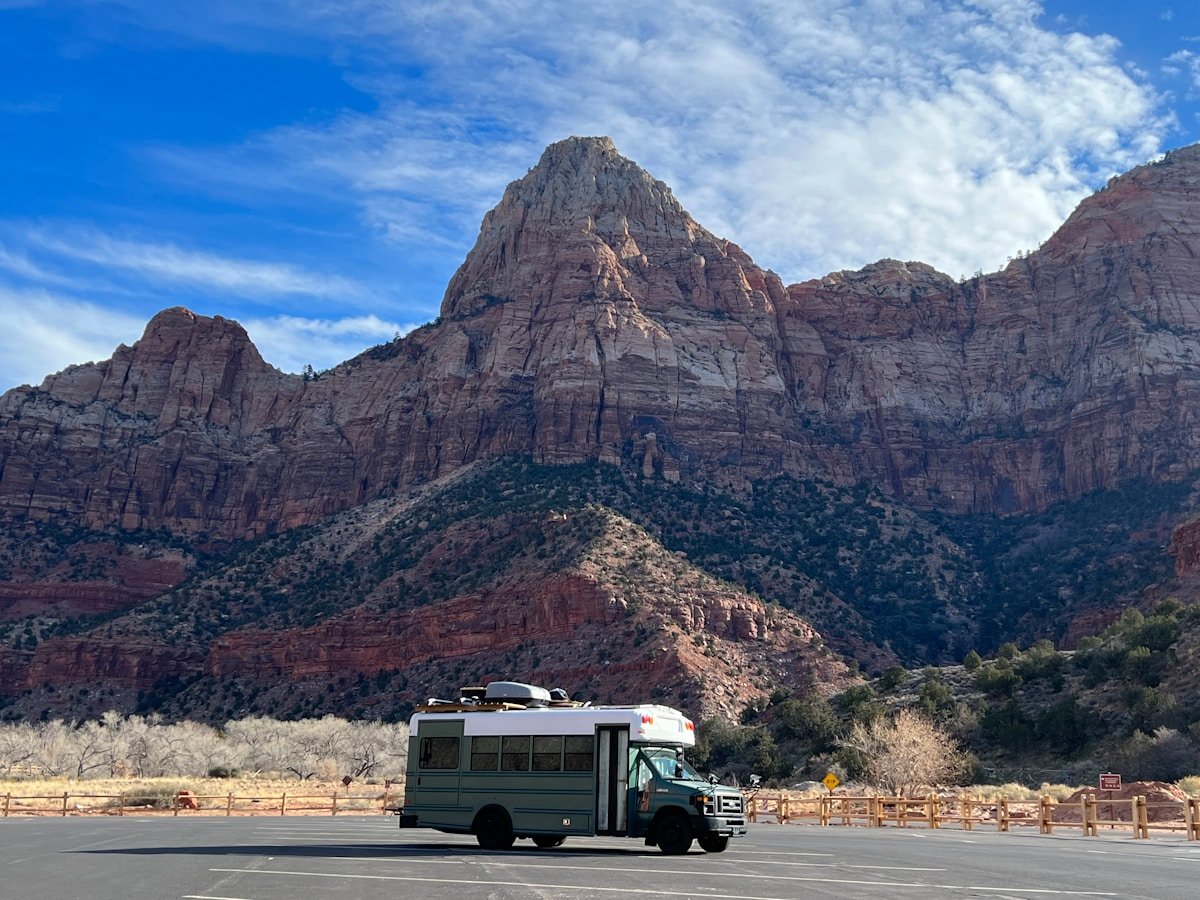 RV driving on a road in front of red rock mountains near Moab